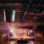 Cubeta metálica colgada sobre un gimnasio decorado para el baile de graduación, con una corona en primer plano